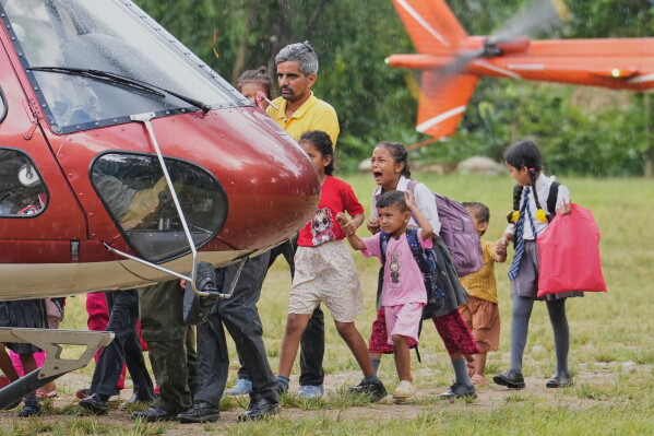 A girl cries as she boards a helicopter with her family after being rescued from their village, which was cut off by flash flooding in Nepal's Nuwakot district, Friday, Aug. 28, 2026. (AP Photo/Rajesh Kumar Singh)