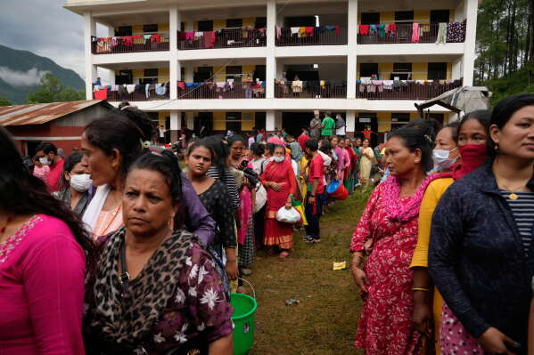 People affected by recent flash floods line up to receive aid at a school turned into a shelter in Nuwakot district, Nepal, Thursday, Sept. 3, 2026. (AP Photo/Dar Yasin)