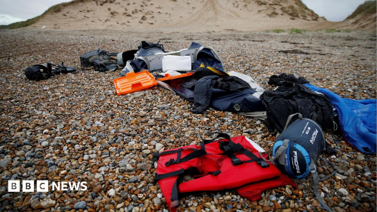 A red life jacket, bags, and other belongings left abandoned on a stony beach, following the death of at least 30 migrants on the English channel in November 2021
