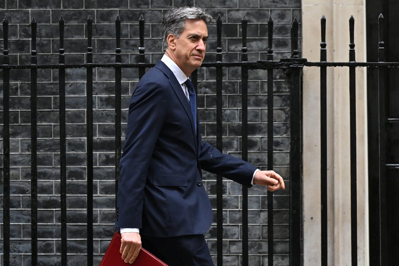 A side profile of a man walking, wearing a suit.