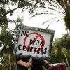 A person holds signs during a nationwide protest against AI data center expansion in New Port Richey, Florida on July 18, 2026.