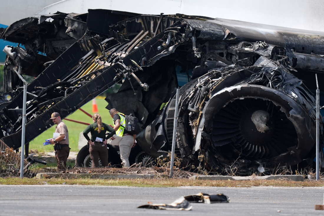 Officials stand near a destroyed wing and engine as they inspect an Amazon cargo plane two days after it overshot a runway at Miami International Airport, Tuesday, Sept. 8, 2026, in Miami.
