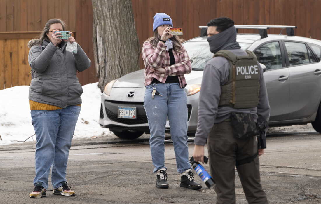 Observers film ICE agents in Minneapolis in February. A new lawsuit alleges that the federal government is trying to intimidate observers who monitor immigration enforcement operations.