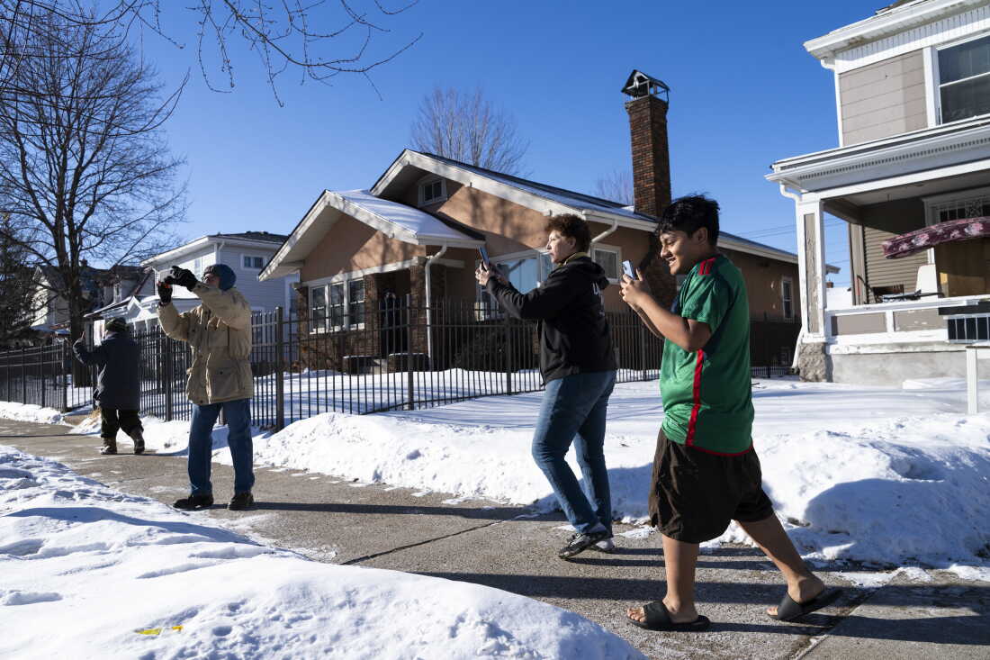 Observers film as ICE agents leave a residence on January 28, 2026 in Minneapolis. NPR has documented numerous instances of other people legally observing ICE, describing intimidation and threats from the federal government.