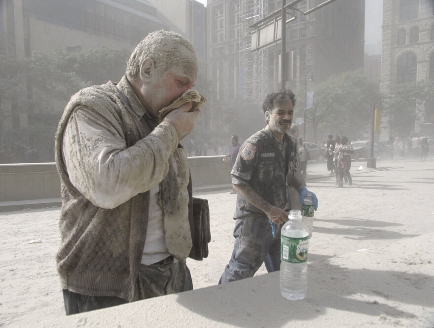 In this Sept. 11, 2001 file photo, a man wipes ash from his face after terrorists flew two airplanes into the World Trade Center towers, causing them to collapse.