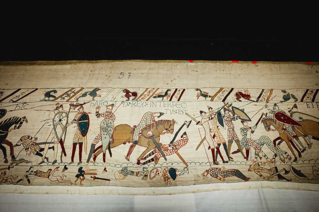The scene depicting King Harold's death on the Bayeux Tapestry at the British Museum in London. The Bayeux Tapestry is an embroidered cloth nearly 230 feet long that depicts the events leading up to the Norman Conquest of England in 1066, led by William the Conqueror, challenging Harold II, King of England, and culminating in the Battle of Hastings. The 11th-century work arrived in London in July for a 10-month e