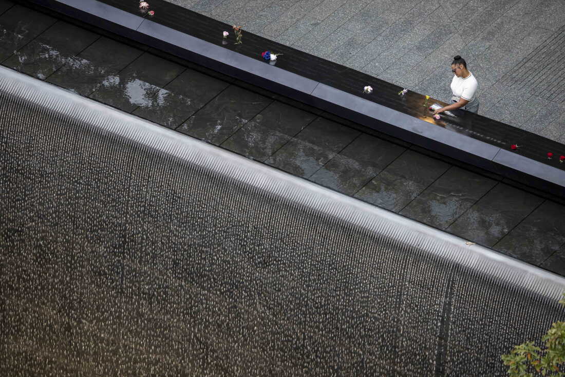 A woman places flowers at the September 11 memorial plaza in Lower Manhattan ahead of a ceremony commemorating the 25th anniversary of the Sept. 11, 2001, attacks at the National September 11 Memorial in New York on Friday.