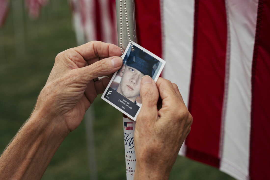 Suzi Mahe, a 66-year-old volunteer from University City, adjusts a portrait honoring Army Cpl. Jonathan Schiller of Iowa at the “Flags of Valor” installation on Thursday, Sept. 10, 2026, at Art Hill in Forest Park, St. Louis, Mo. More than 7,600 American flags honor service members, first responders and civilians who died in the Sept. 11 attacks and subsequent military conflicts.