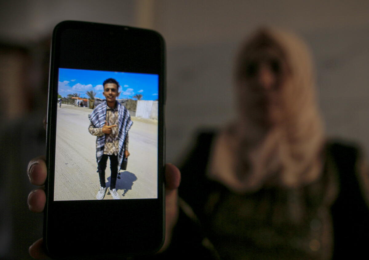 Mahmoud al-Drimly is pictured on the screen of a phone held by his mother.