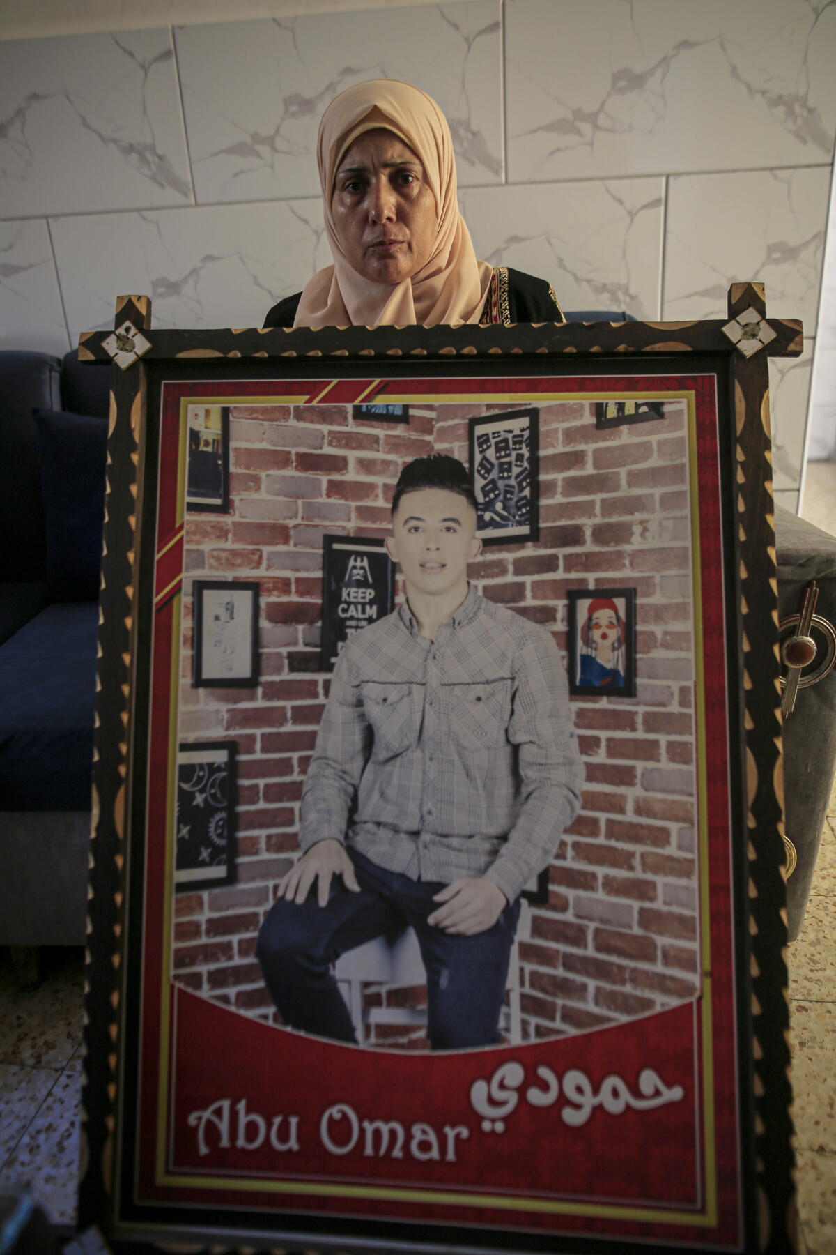 Aida al-Drimly, with a photo of her son Mahmoud al-Drimly. 