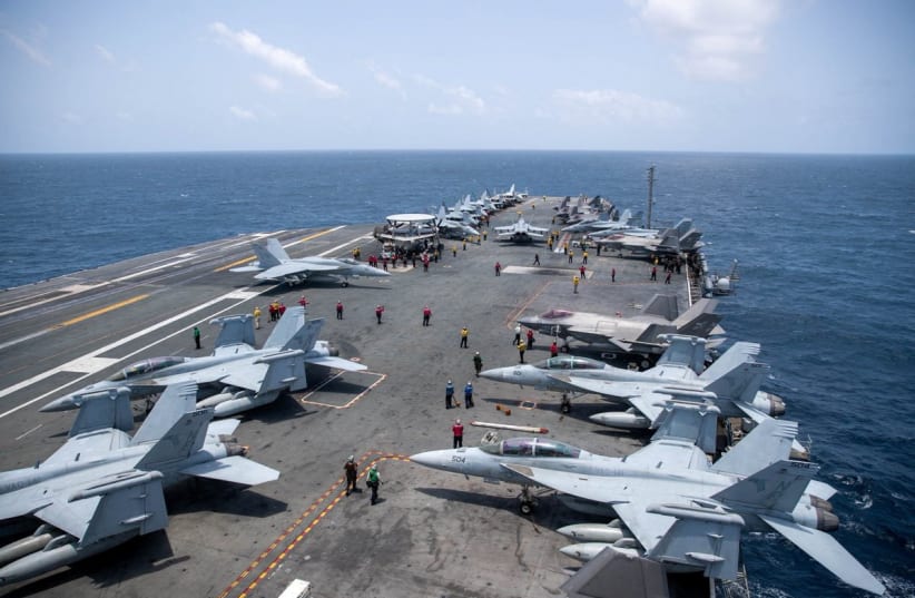 US Navy sailors work on the flight deck of the aircraft carrier USS George Washington as it transits the Arabian Sea to support US military operations in the war with Iran August 20, 2026. 