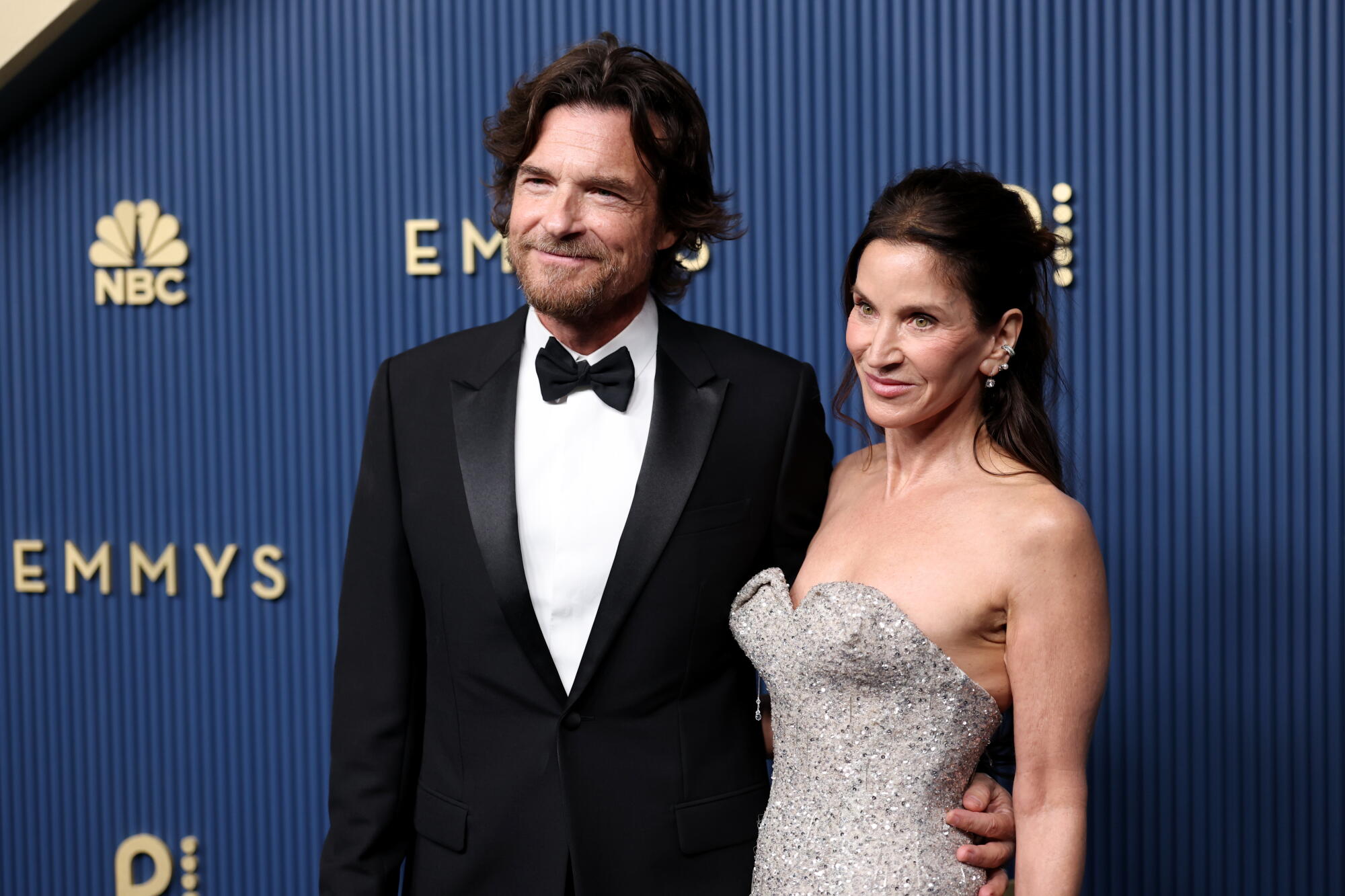 Jason Bateman and Amanda Anka pose on the Emmys blue carpet. 