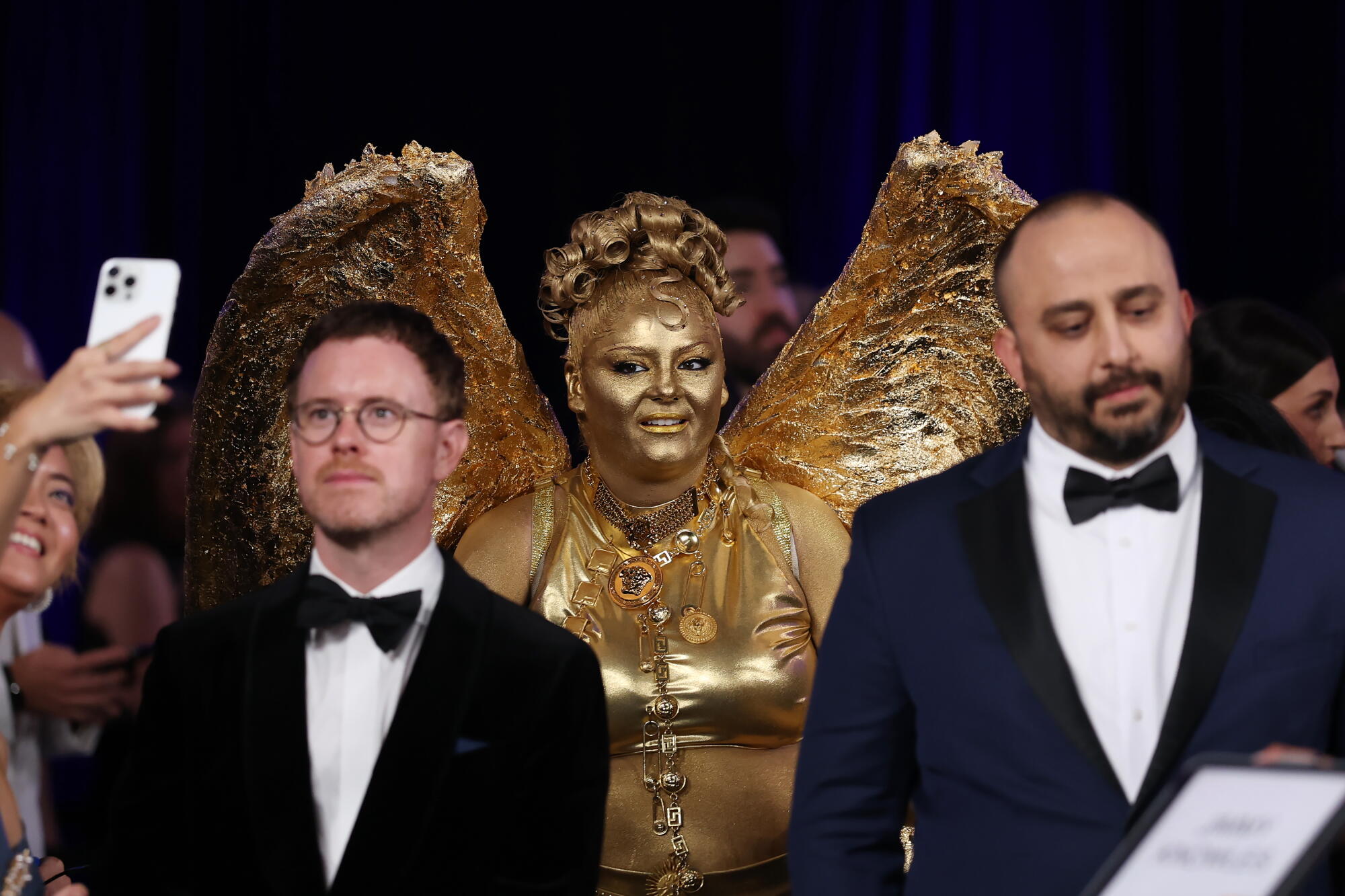 Megan Stalter, covered in gold paint, resembles an Emmy statue. 
