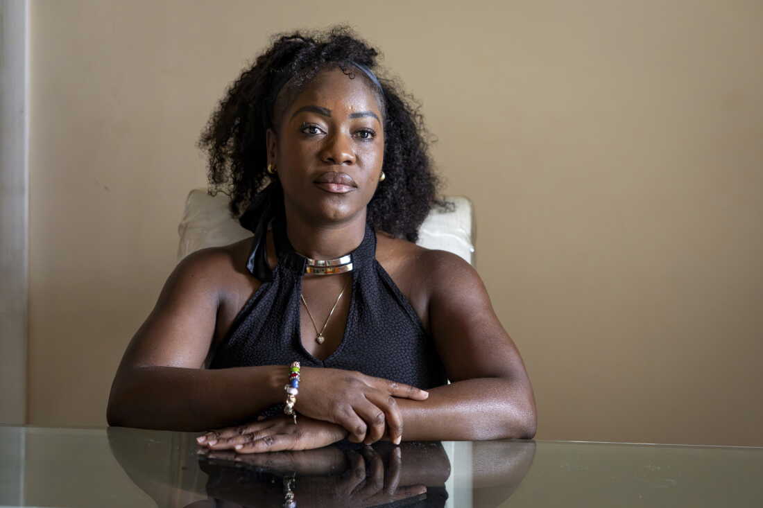 Herlain, who asked NPR to withhold her last name, poses for a portrait at her home in North Lauderdale, Fla.