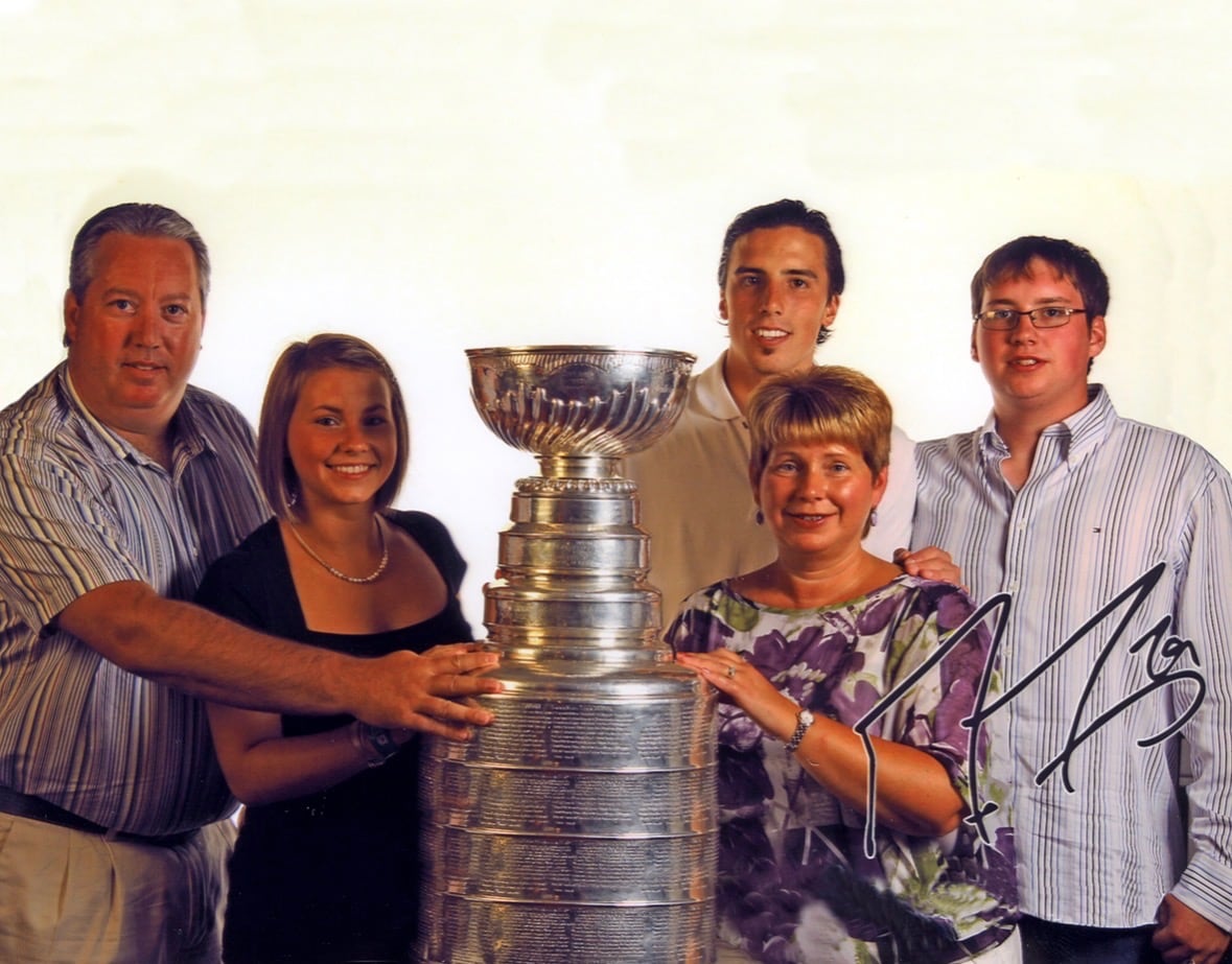 The Hawkins and Marc-Andre Fleury take a photo with the Stanley Cup.