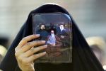 A Shiite Muslim pilgrim holds up a picture of Iranian Supreme Leader Ali Khamenei and Hezbollah leader Hassan Nasrallah in Najaf, Iraq, on Dec. 9, 2014.
