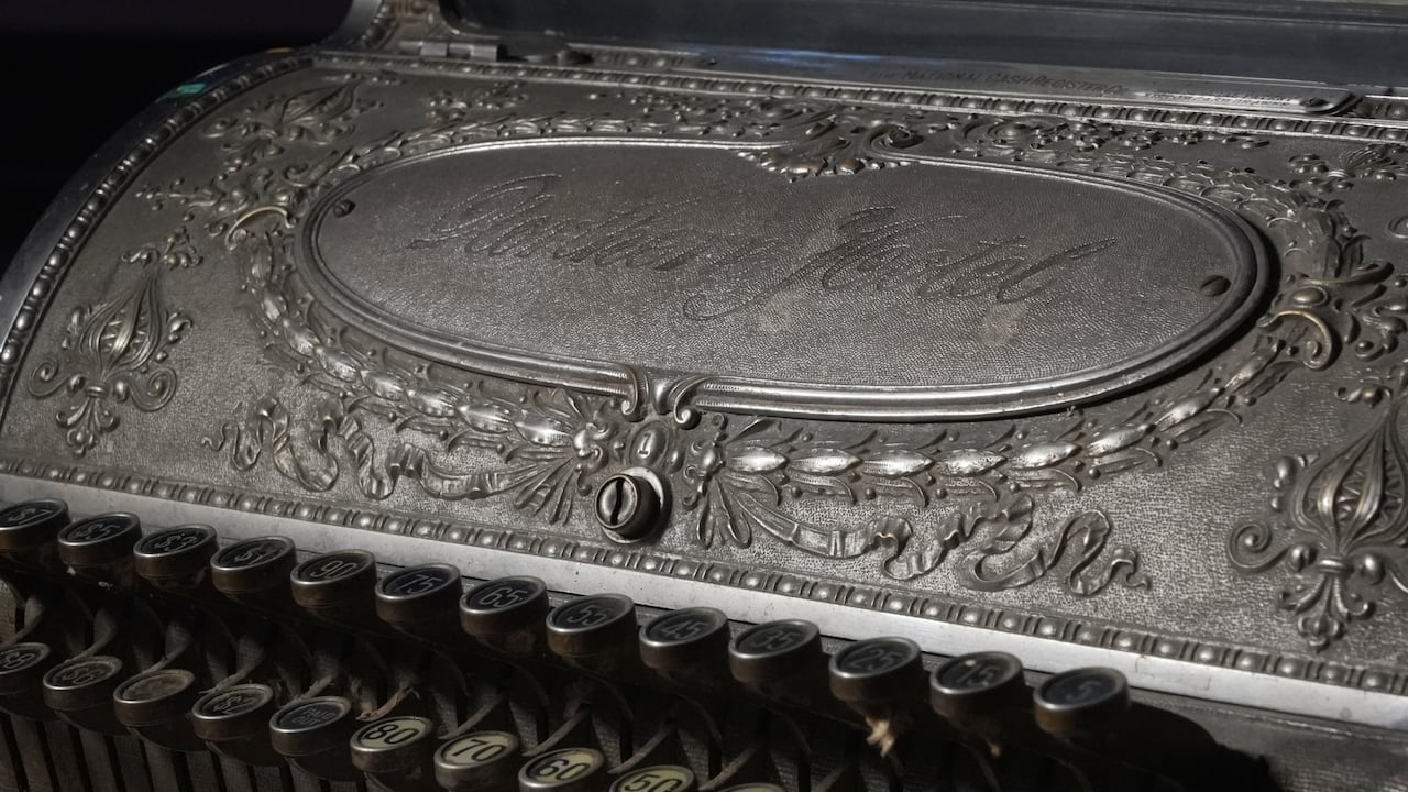 Close up of a mechanical cash register engraved with the words "Northern Hotel."