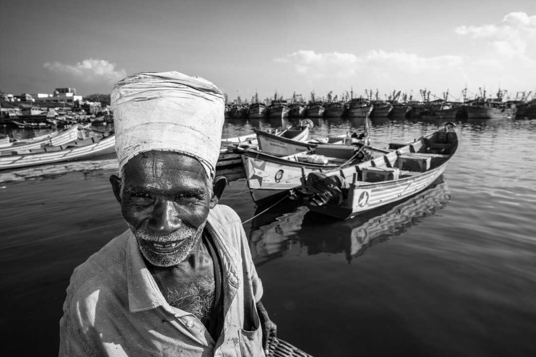 Pavadairayan, 60, a migrant laborer known as a “basket man,” carries fish from boats to the auction house at Kasimedu Fishing Harbour in Chennai, India.