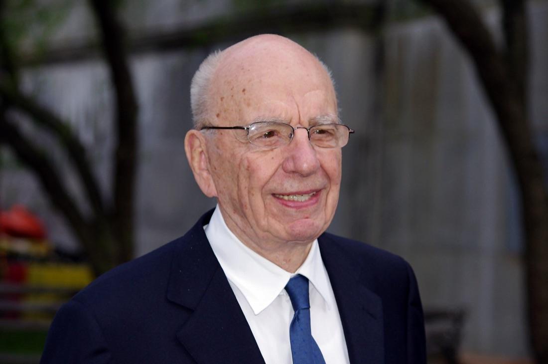 Rupert Murdoch in a dark suit and blue tie, smiling, at a Vanity Fair party in New York in 2011