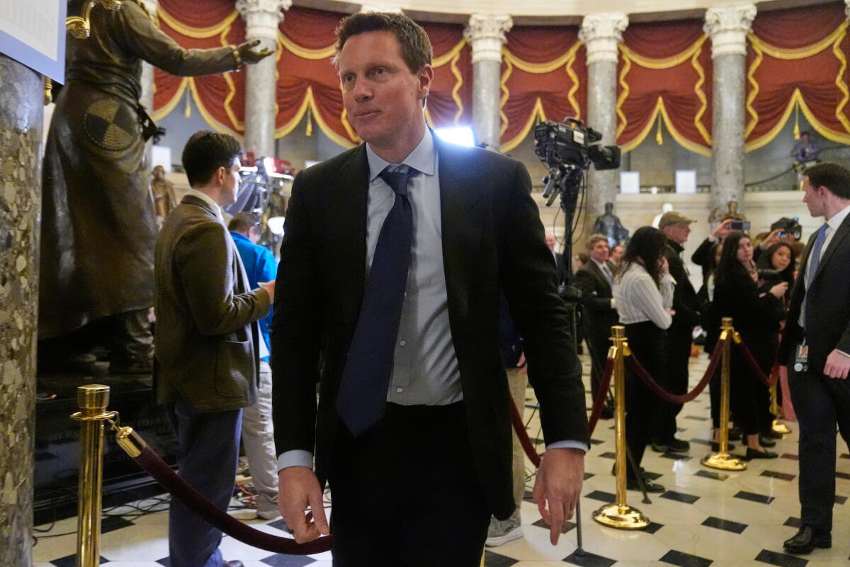 David Ellison walks in a  business suit