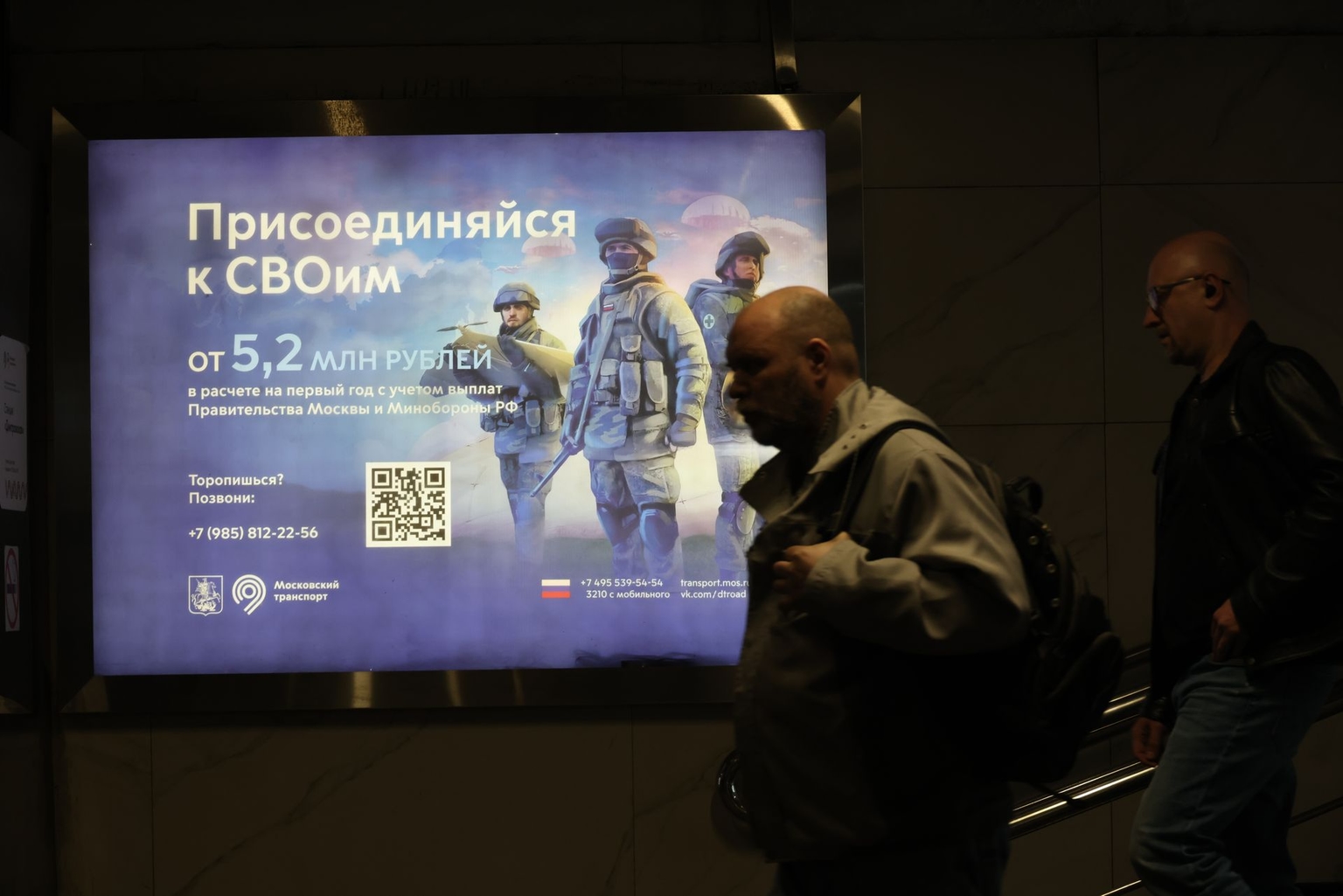 Men walk past an army recruitment billboard in Moscow, Russia, on March 31, 2026.