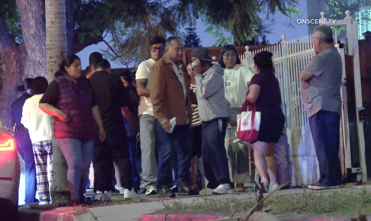 People stand together near a fenced yard.