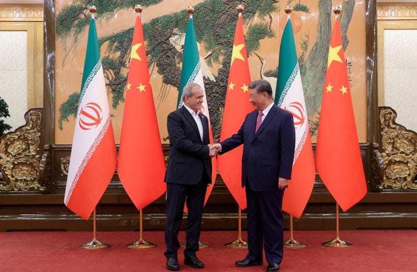 Iranian President Masoud Pezeshkian and Chinese President Xi Jinping shake hands as they meet in Beijing, China, September 2, 2025.