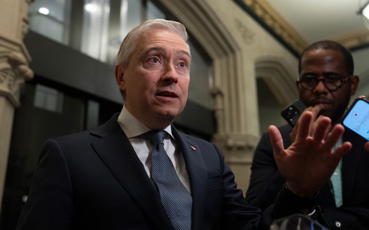 A man in a suit speaking into a microphone.
