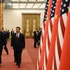 China's President Xi Jinping and President Trump walk past a line of alternating U.S. and Chinese flags.