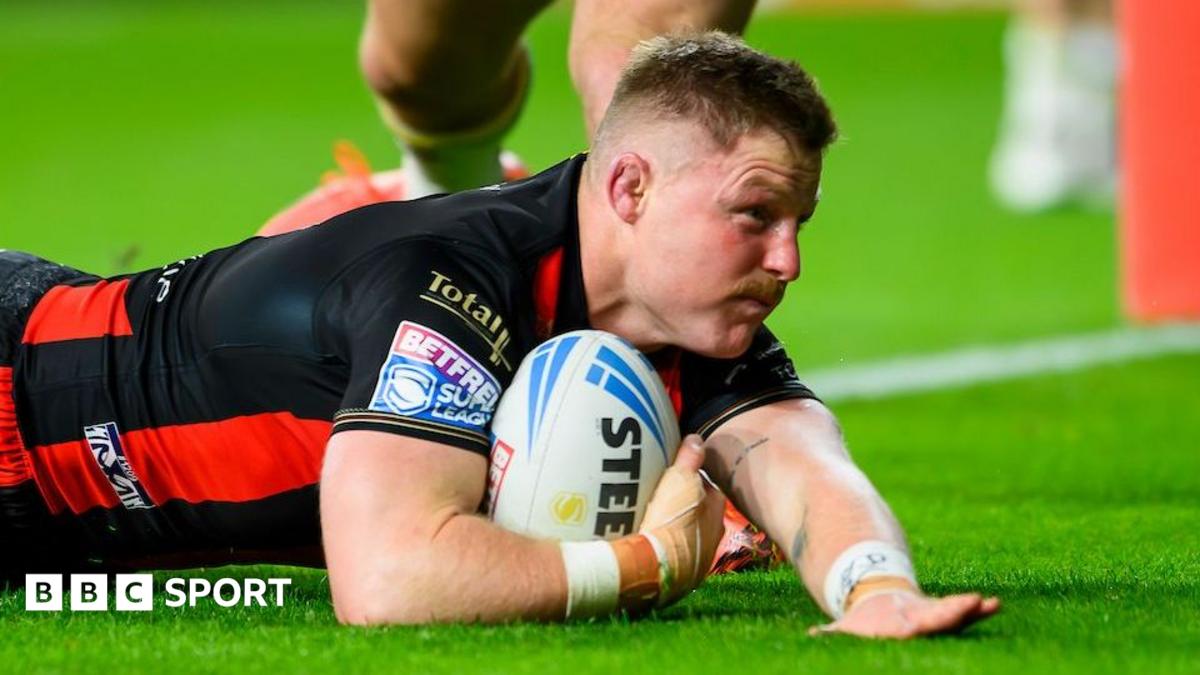 Warrington Wolves' Luke Yates sliding with the ball in his right hand to score for his side against Leeds Rhinos