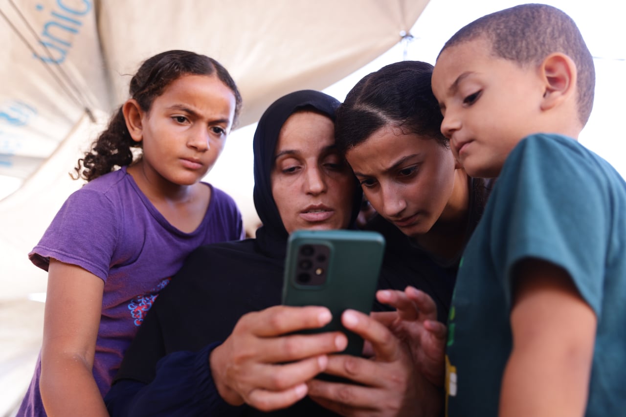 A woman looks at a phone in her hand.