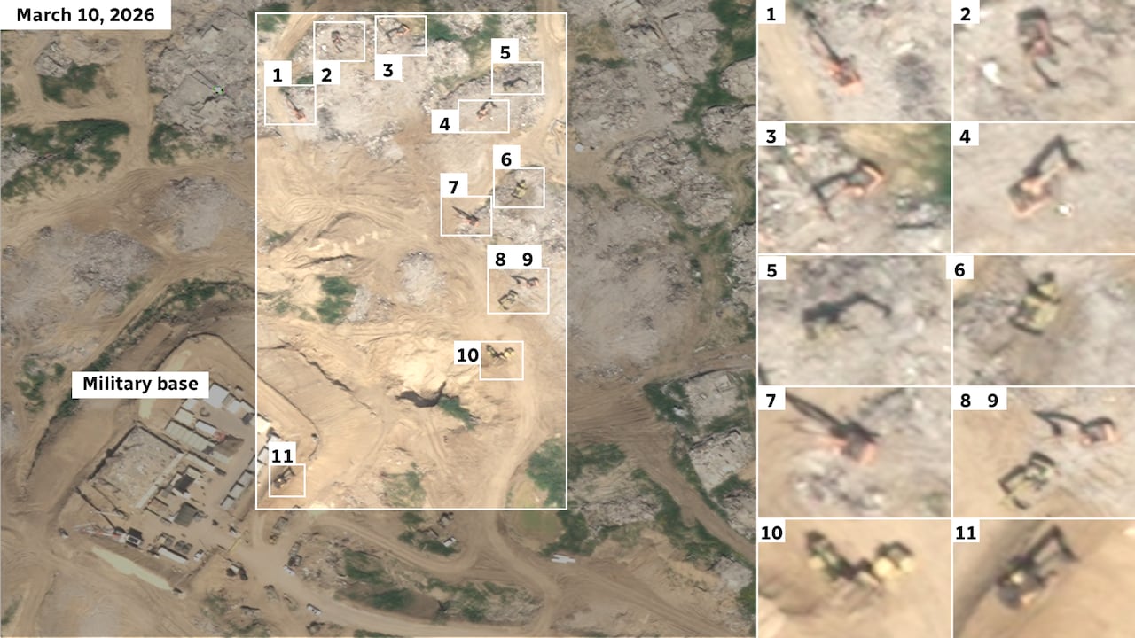 Satellite image showing excavators and trucks amid rubble.