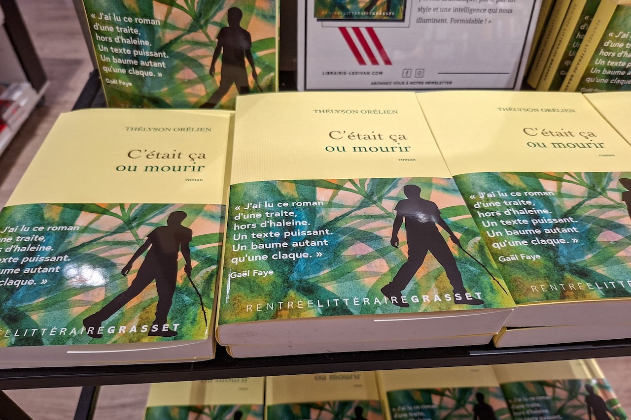 Copies of the novel C'était ça ou mourir, which translates to "It was either that or die," by Thélyson Orélien are displayed on a bookstore table in Paris