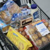 A grocery cart is full of food items.