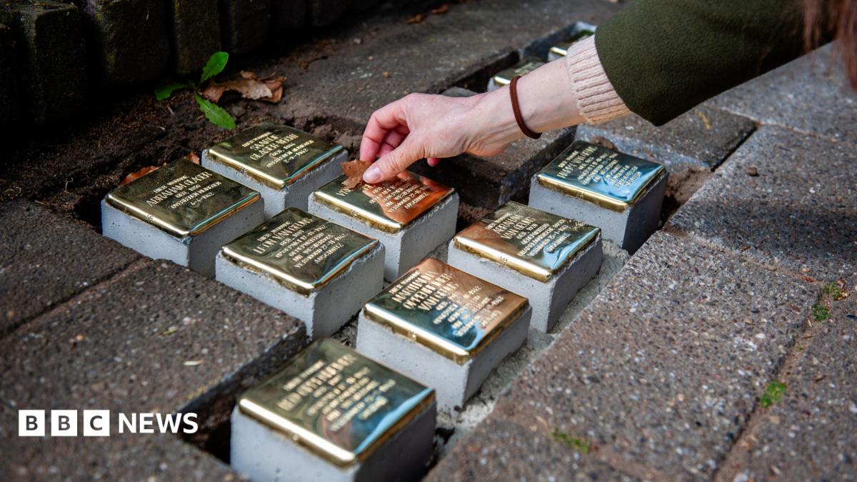 Small blocks of stone with brass on top are placed as part of a memorial on the pavement in front of houses where Jewish victims lived in Nijmegen in the Netherlands