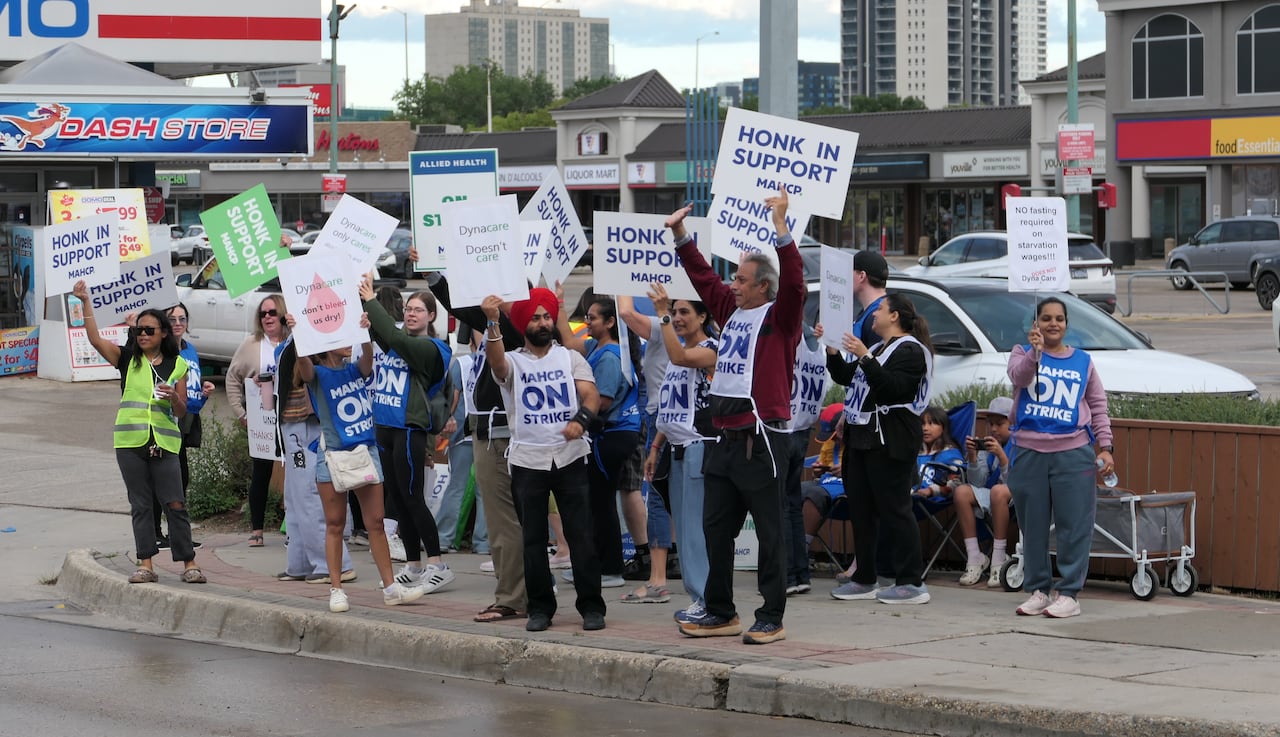 A group of workers picket along a street.