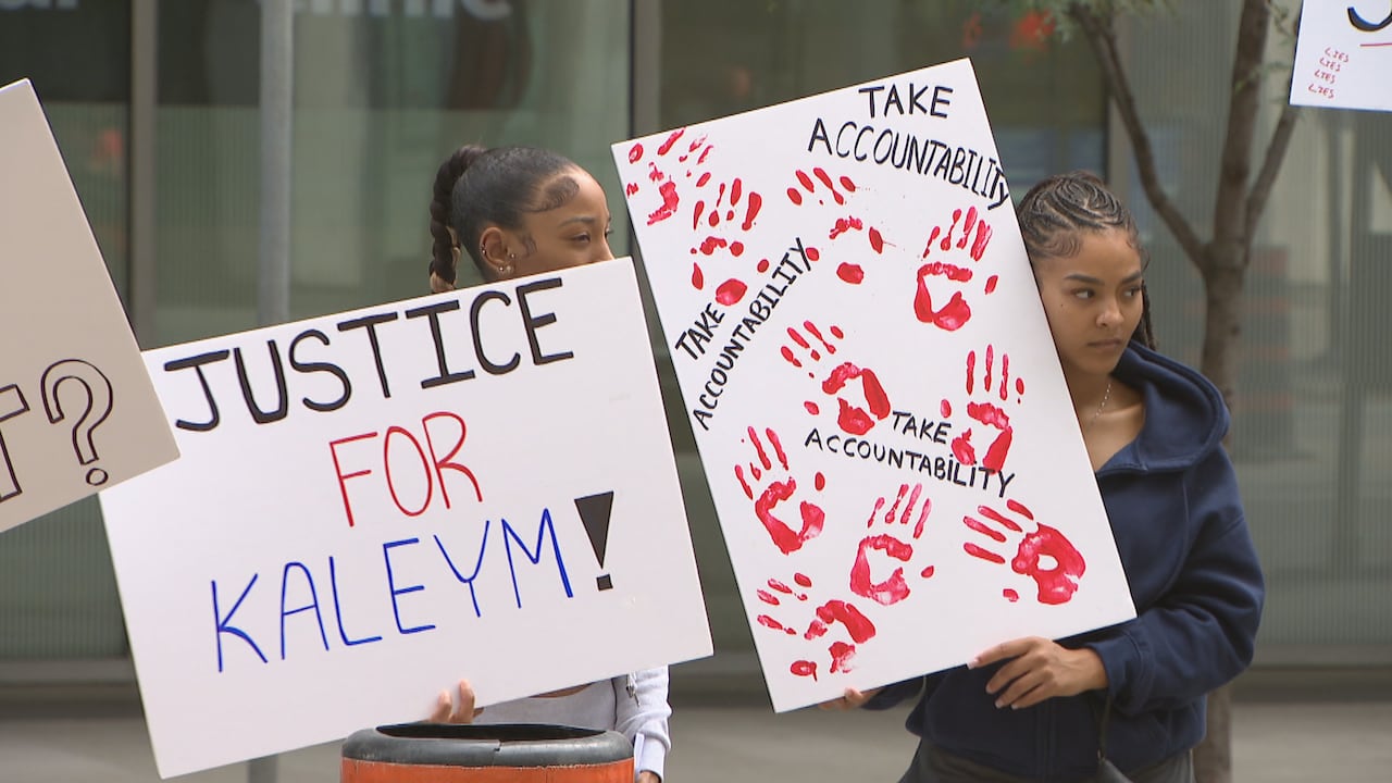 People standing holding up posters calling for accountability, justice