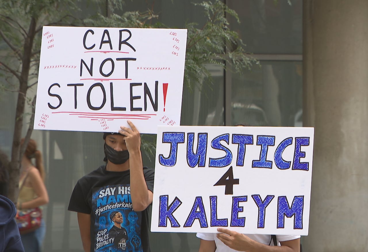 People standing holding up posters calling for justice