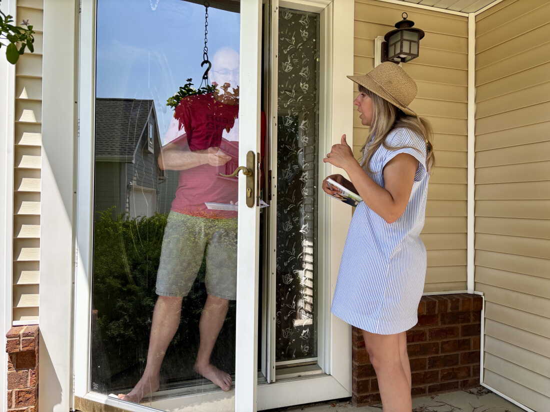 Sarah Trone Garriott canvases for votes in Iowa. She is one of several ordained clergy members running for Congress as a Democrat this year.