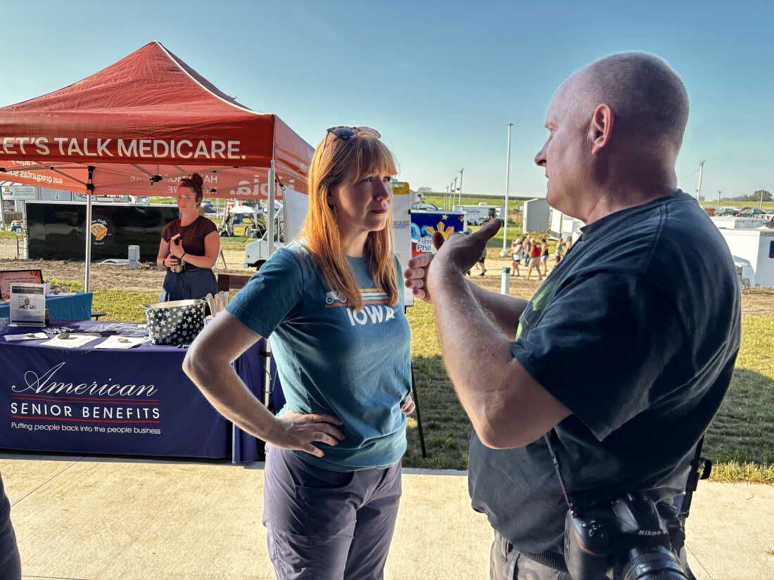 Lindsay James speaks to Kip Ladage, an Iowan concerned about health care, at the Bremer County Fair town of Waverly.