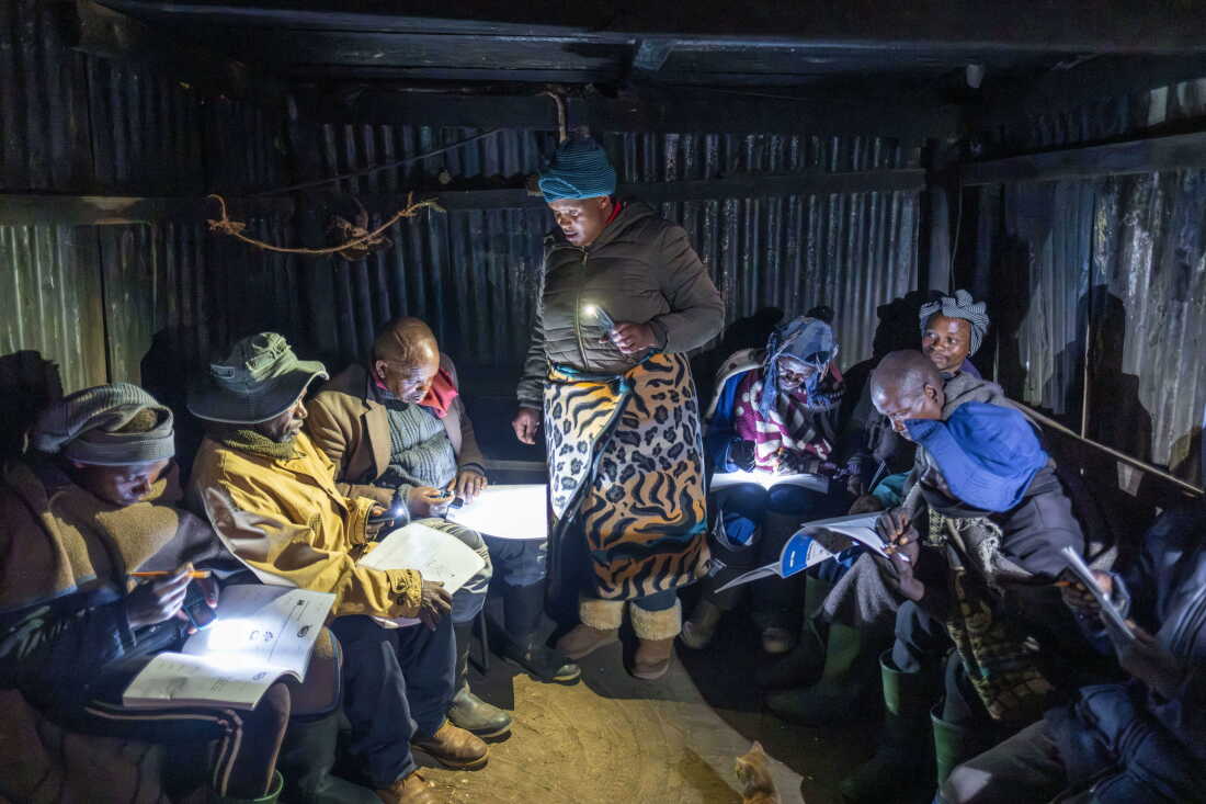 Mampho Makha teaches students at a rudimentary night school in the village of Ha Ntsokoane in Thaba Tseka, Lesotho. Many of the students are shepherds who missed out on formal schooling during childhood. The school operates on a shoestring budget and lacks electricity, so students study by the light of their phones.
