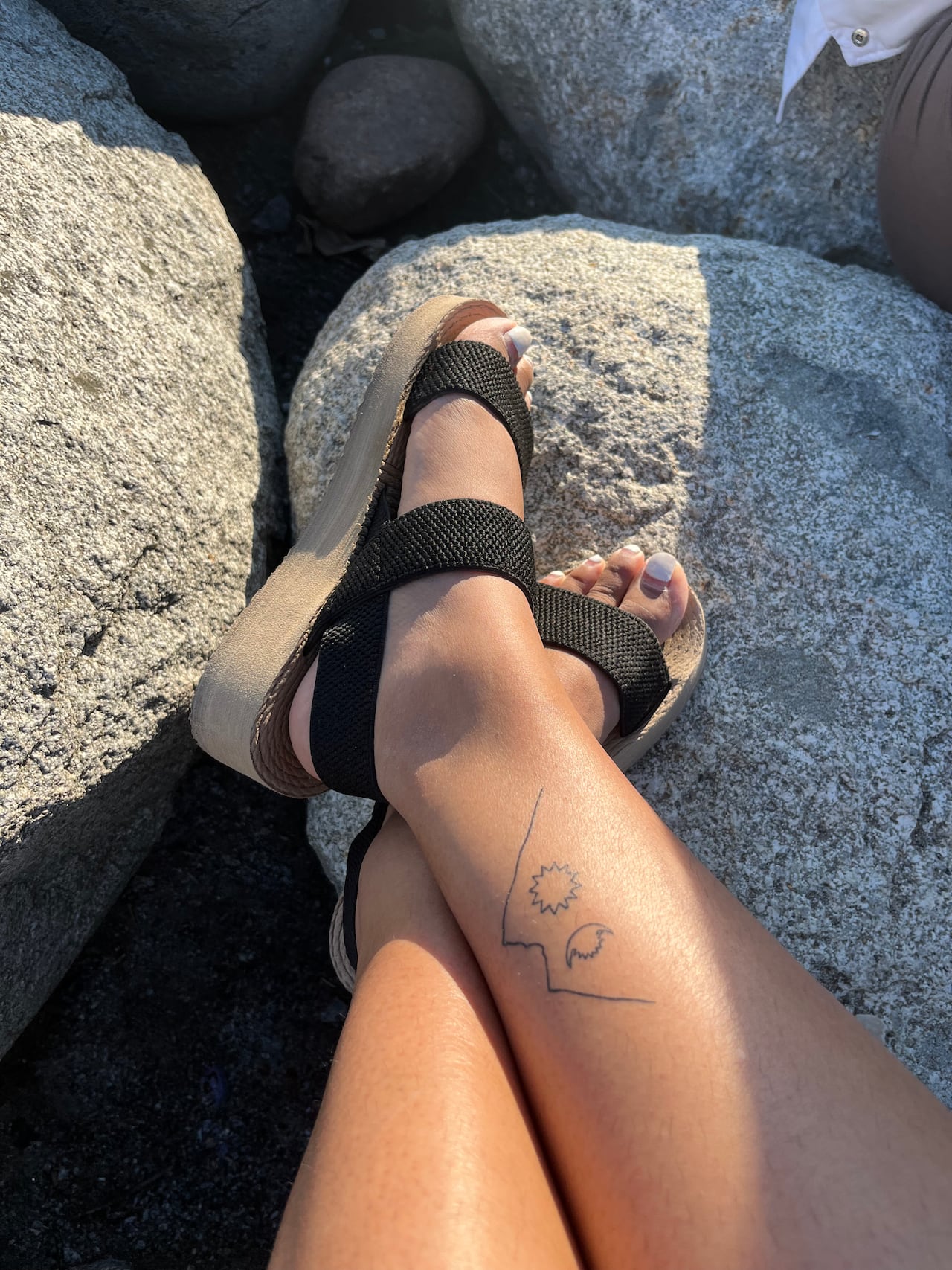A tattoo of a mountain on a woman's leg.