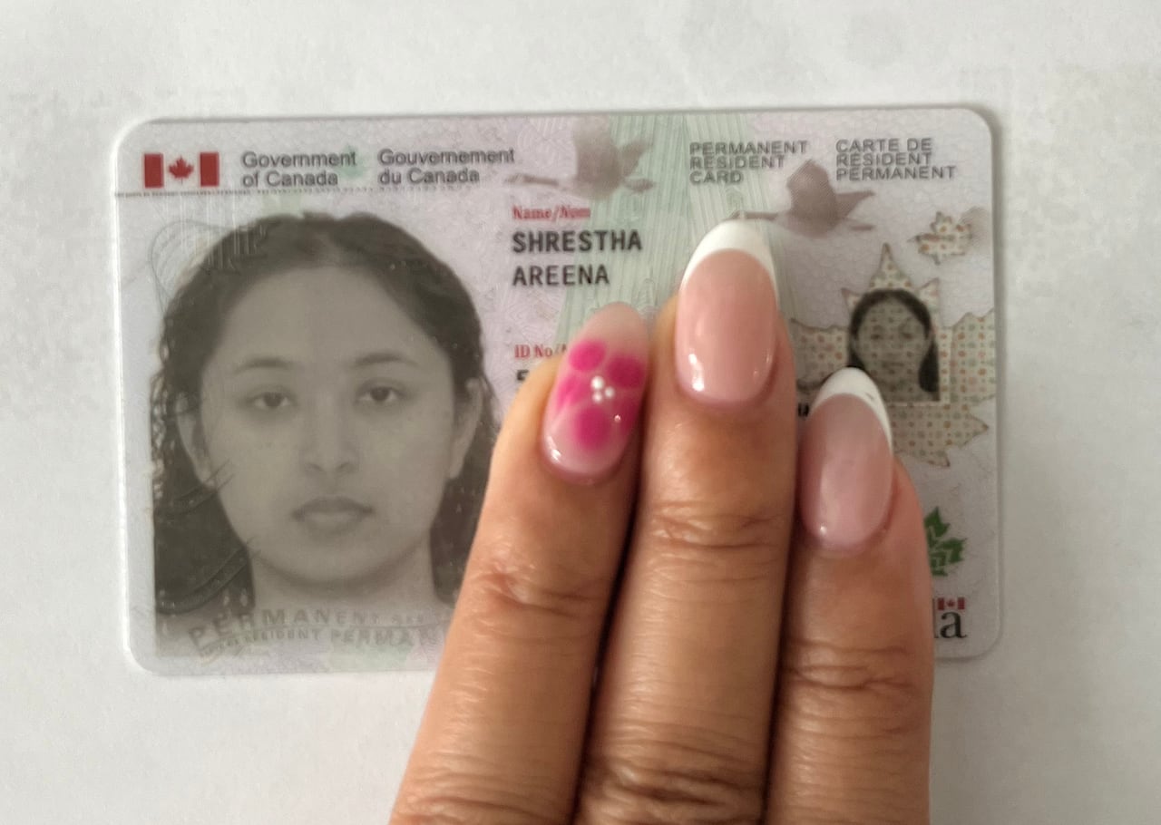 A hand partially covers up a PR card for a woman.