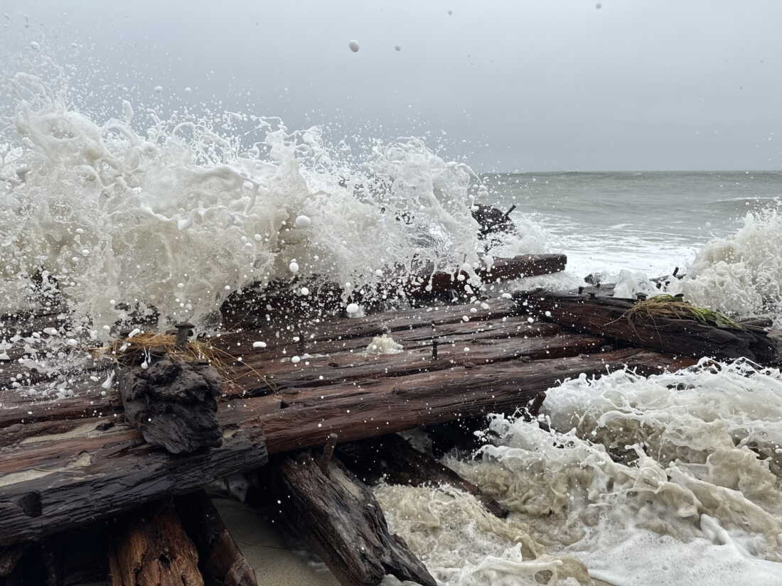 Waves pound the remains of a ship believed to be have gone aground in a storm in 1884