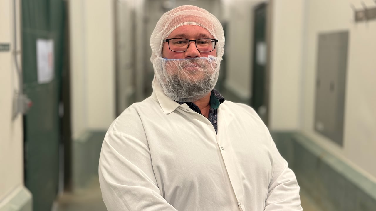 A man in protective wear faces forward with a neutral expression.