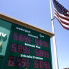 An American flag on a tall flagpole flies above a sign displaying gas prices in red digital numbers at a gas station in Arcadia, California, on May 11.
