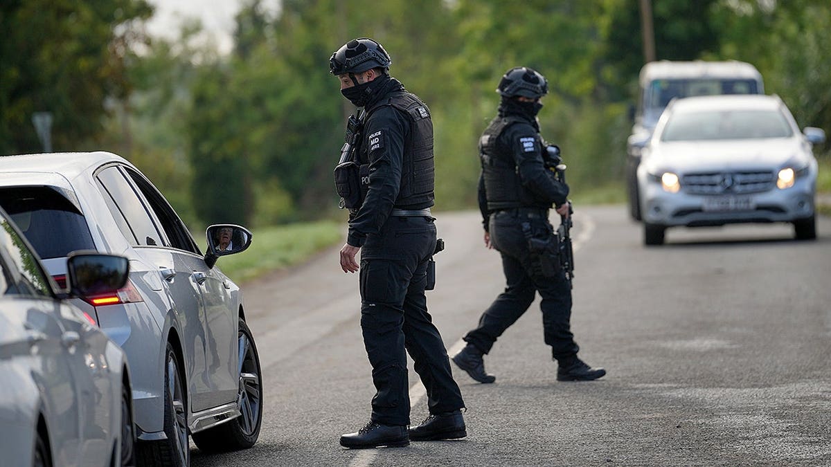 Police stand guard on a road leading to RAF Fairford in Fairford, England.