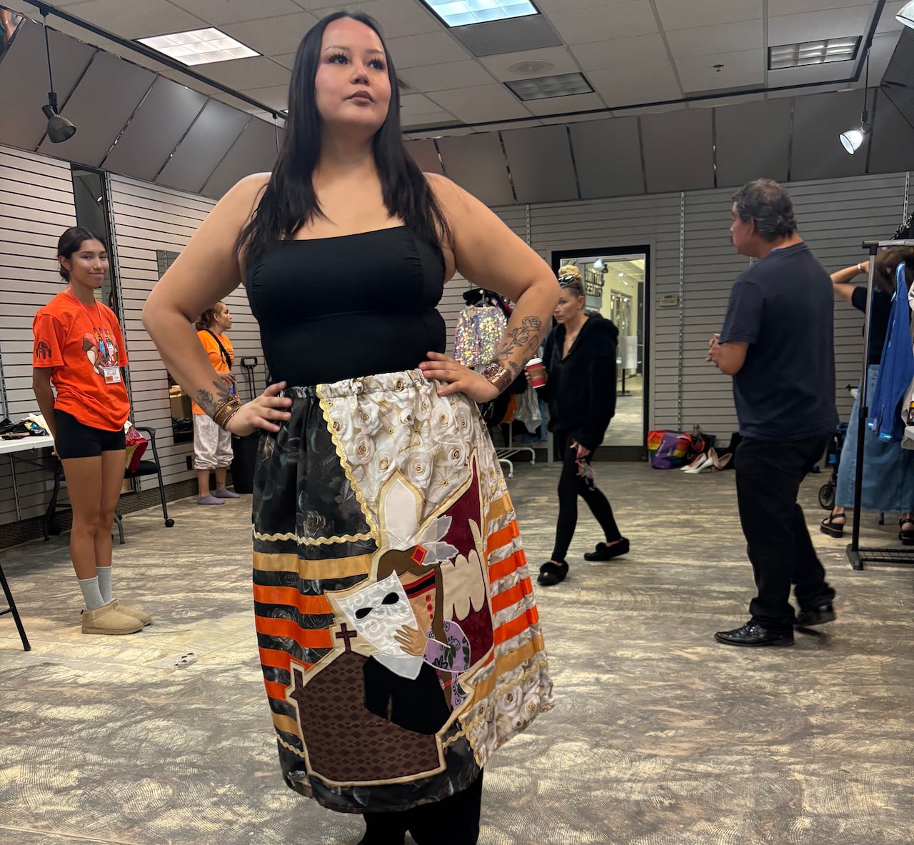 A woman wears a skit that features a visual of a character holding a mask.