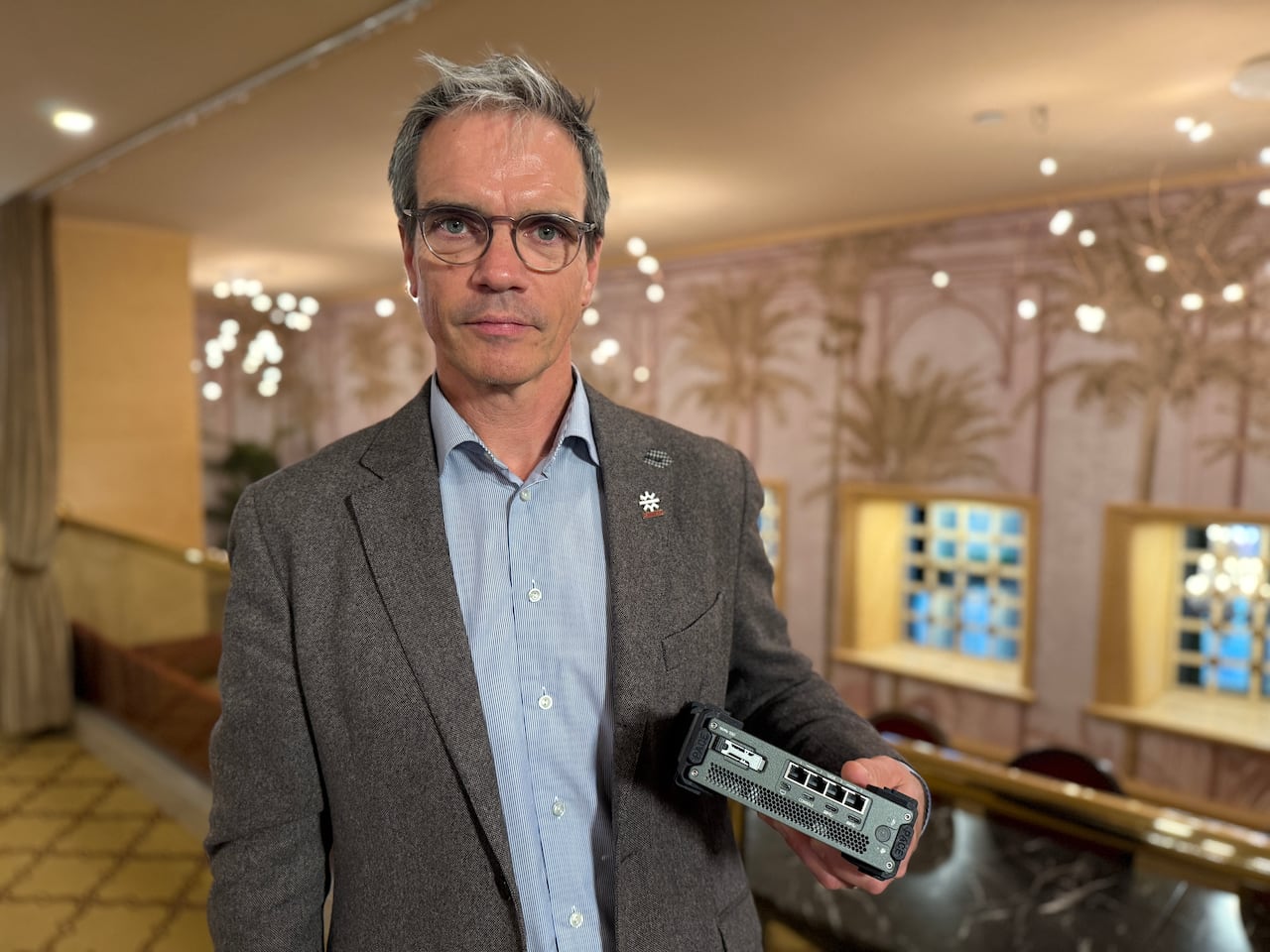 man standing and holding a mini computer server