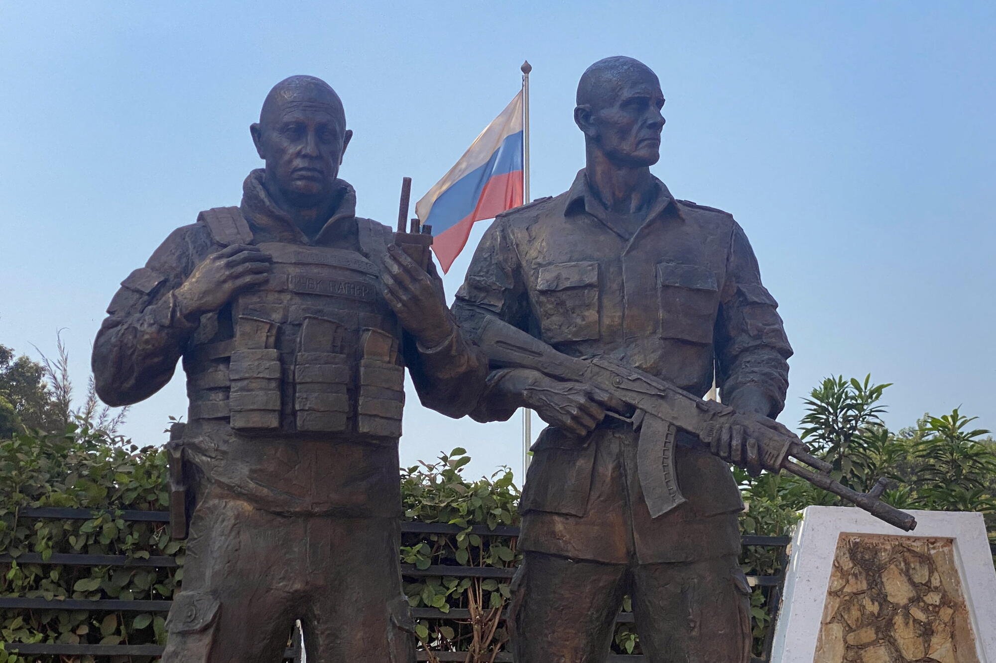 Bronze statue of two men in military attire, one holding a rifle 